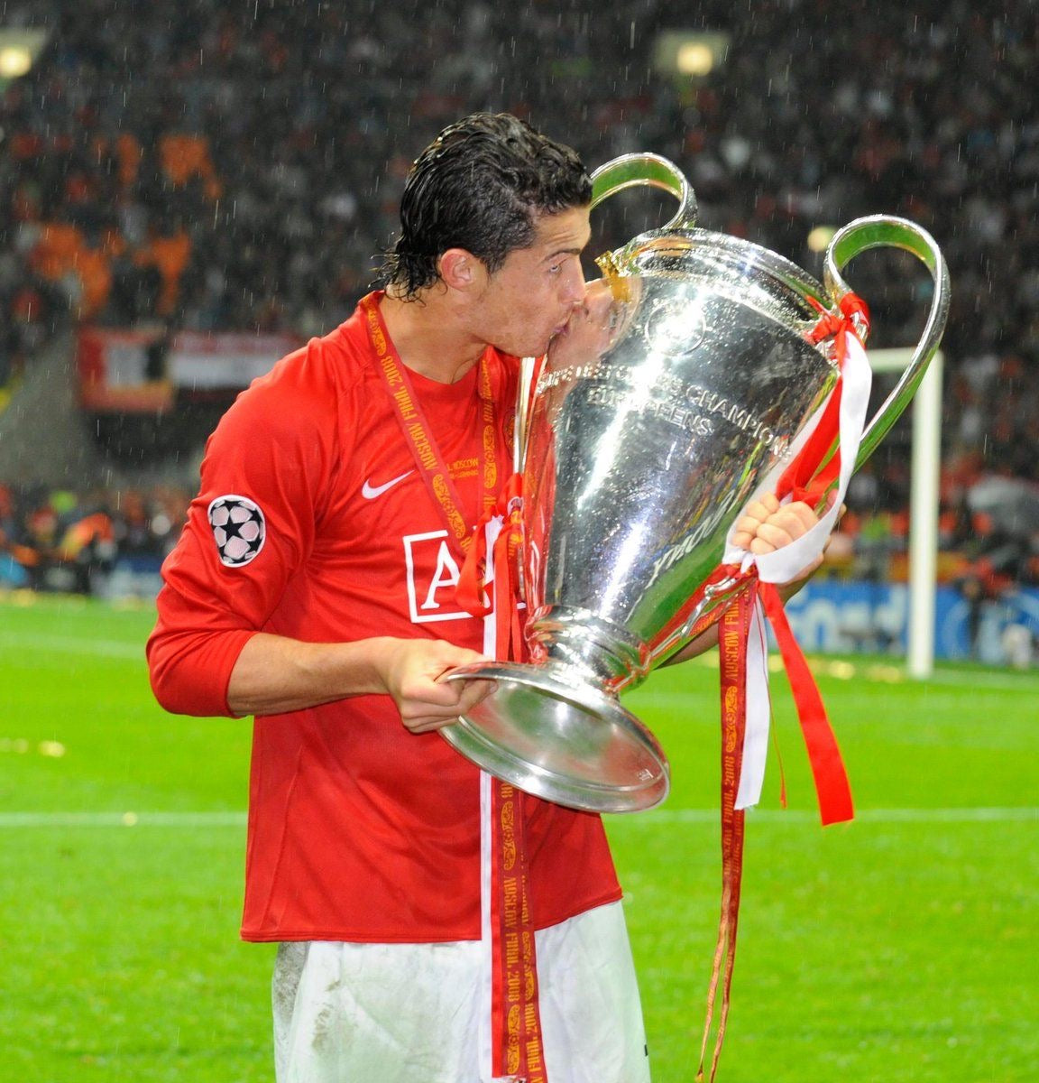 Cristiano Ronaldo besando el trofeo de Champions League con jersey retro Manchester United 2008 manga larga.
